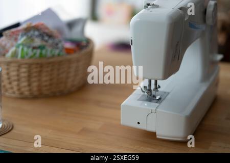 A sewing machine on a wooden table in a room. Concept of independent sewing. Stock Photo