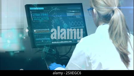 Image of data processing over caucasian female scientist using computer in laboratory Stock Photo