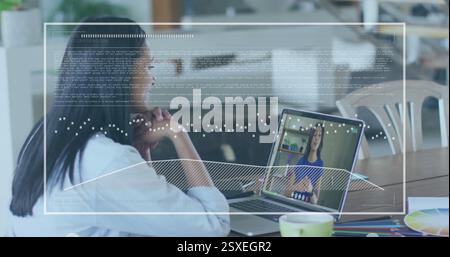 Image of data processing over biracial businesswoman using laptop for image call in office Stock Photo