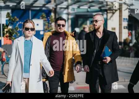 Group of young professionals walking confidently through urban area Stock Photo