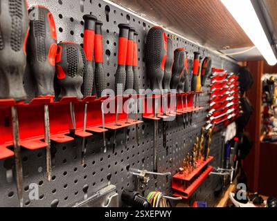 Set of organized different tools hanging on a wall in a garage Stock Photo