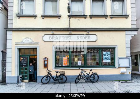 The Neder Brewery in Forchheim's old town welcomes guests beneath its "Brauerei Neder" lettering above the entrance, with two bicycles leaning against the cream-coloured façade. The brewery was first documented in 1554 and is considered the oldest still-operating brewery in Forchheim. St.-Martin-Straße, Forchheim, Bavaria, Germany. Stock Photo