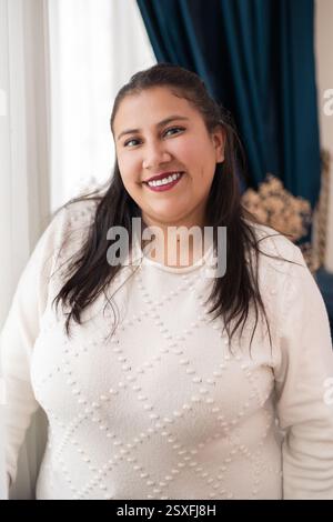 A woman smiling in her home, perfect for content about happiness, home life, wellness, and positive living. Stock Photo