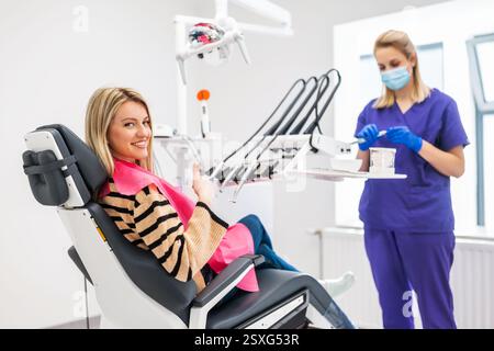 Happy young woman in modern dental clinic. She is looking at camera and smiling. Stock Photo