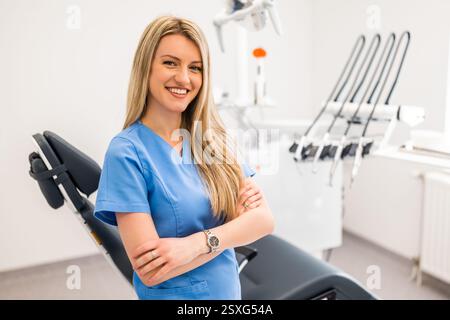 Portrait of happy dentist in her dentist's office. Confident adult woman working in a dental clinic. Stock Photo