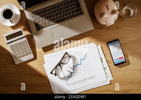 Corporate business desktop with printed financial charts and digital chart on a mobile app Stock Photo