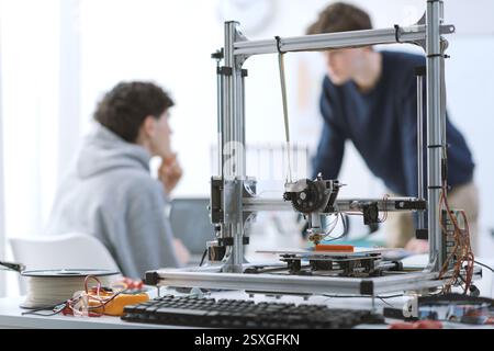 Students talking together in the 3D printing lab, technology and education concept Stock Photo