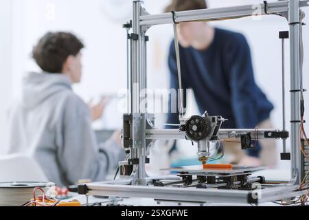 Students talking together in the 3D printing lab, technology and education concept Stock Photo