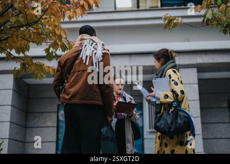 Multiracial people collaborating outdoors in autumn setting with documents Stock Photo