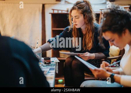 Young women together engaging in creative art activity in cozy indoor setting Stock Photo