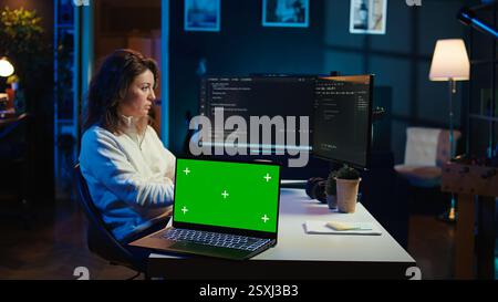 Programmer designing and developing software applications using isolated screen laptop. IT professional implementing and maintaining company systems using mockup notebook, camera B Stock Photo