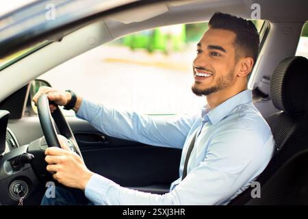 Excited arab guy going to office, driving his car Stock Photo