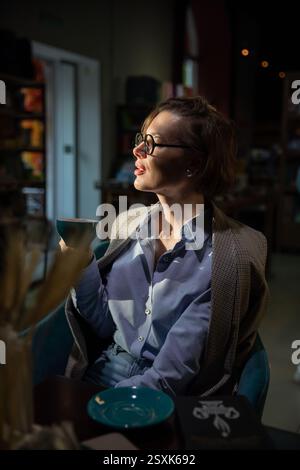Beautiful woman 40 years old reading a book in a restaurant Stock Photo