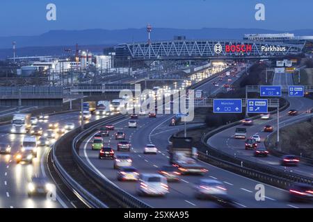 Heavy traffic in the evening on the A8 motorway at the airport. In the background, the Bosch bridge at the trade fair centre and the Swabian Alb. Stut Stock Photo