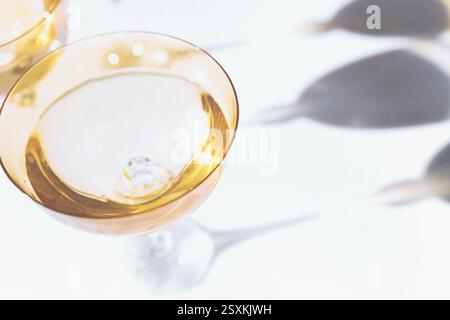 Fancy retro yellow drinking glasses casting hard shadows on background. Grunge and noise effect applied, retro vintage style. Image contains blur. Sel Stock Photo