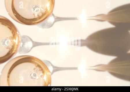 Fancy retro yellow drinking glasses casting hard shadows on background. Retro vintage style. Toned image with yellow color. Image contains blur. Selec Stock Photo