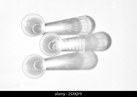 Fancy retro drinking glasses casting hard shadows on background. Retro vintage style. Black and white image. Image contains blur. Selective focus Stock Photo