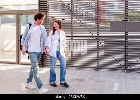 man and woman walking together holding hands Stock Photo
