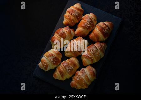 Warm fresh pastry on a dark stone tray Stock Photo