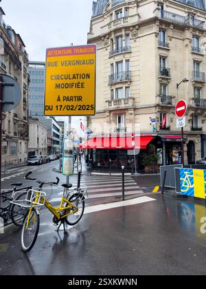 City street with construction signage and bicycles on a rainy day Stock Photo