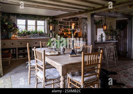 Lit candles on wooden kitchen table in renovated East Sussex Tudor farmhouse dating from 1540, England, UK. Stock Photo