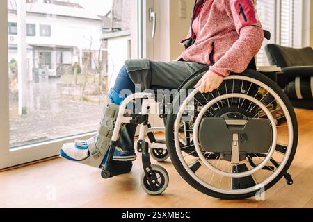 Detail or woman in a wheelchair with leg brace after sport injury Stock Photo