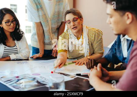 High school students engage in a collaborative classroom setting with their teacher, focusing on a group project discussion and brainstorming session. Stock Photo