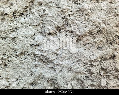 Close up view of a roughly textured white concrete wall, providing a unique and abstract backdrop Stock Photo