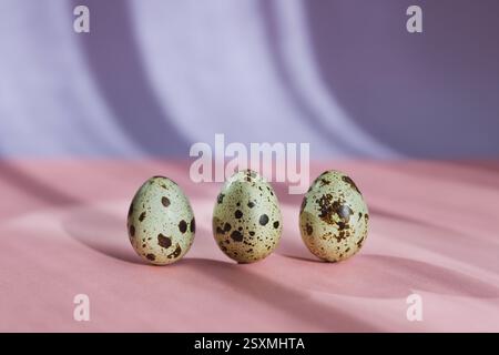 Three quail eggs on pastel background, Easter Stock Photo