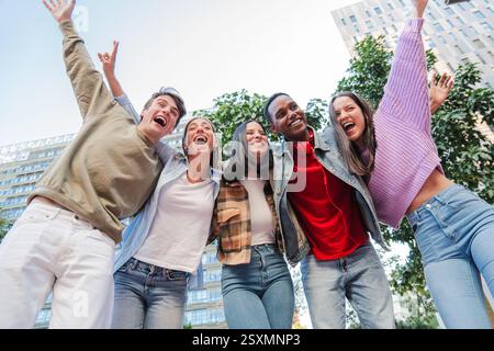 Joyful group of diverse friends celebrating together with enthusiasm and excitement in a lively outdoor gathering while sharing laughter and happiness among each other in a delightful friendship. High quality photo Stock Photo