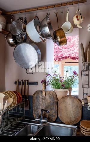 Pan rack and chopping boards in kitchen of Chalford weavers cottage in the Cotswolds, Gloucestershire, England, UK. Stock Photo