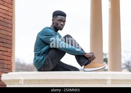 Stylish young man tying his shoelaces while taking a break outdoors Stock Photo