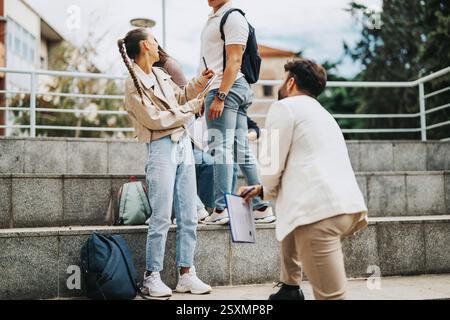 High school students collaborating on outdoor tasks with professor assistance Stock Photo