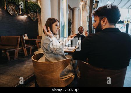Multiracial coworkers having a discussion in a cozy cafe environment Stock Photo