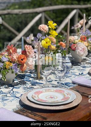 Elegant Outdoor Dining Table with Floral Centerpieces in a Scenic Setting Stock Photo
