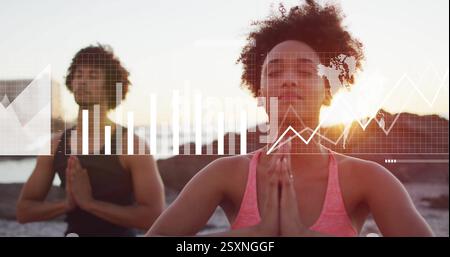 Image of digital data processing over diverse people practicing yoga on beach Stock Photo