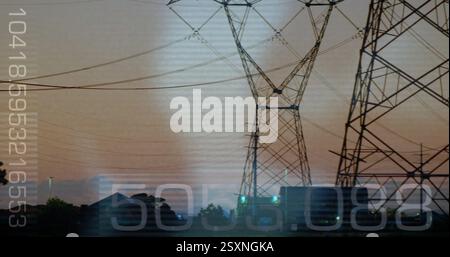 Power lines and transmission towers over data processing image with numbers Stock Photo