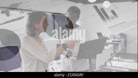 Business data charts and graphs image over two women discussing in office Stock Photo
