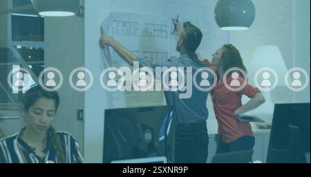 Image of network of people icons over diverse business people in office Stock Photo