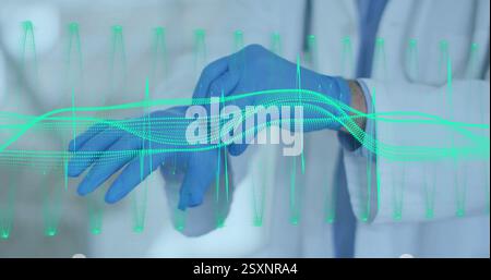 Doctor wearing gloves with heartbeat waveform image over hands Stock Photo