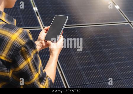 Female engineer at solar power plant using wireless technology to monitor panels Stock Photo