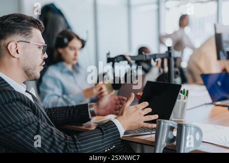 Group of diverse employees working collaboratively at a modern office setting, focused on active discussions and technology. Stock Photo