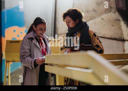 Two people collaborate outdoors while discussing ideas Stock Photo