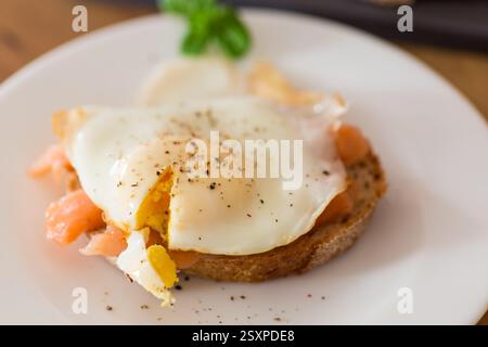 A slice of bread with a cooked egg and lightly salted red fish. Stock Photo