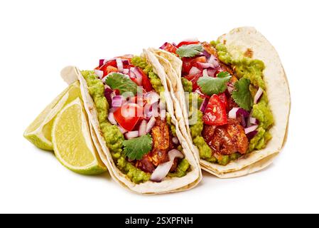 Delicious tacos filled with fresh guacamole, diced tomatoes, chopped onions, and garnished with a lime slice Stock Photo