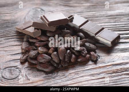 Broken dark chocolate and cocoa beans on the table Stock Photo