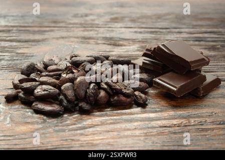 Broken dark chocolate and cocoa beans on the table Stock Photo