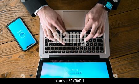 Businessperson working on a laptop in the office or at home, working online remotely. Stock Photo