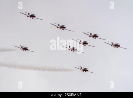 Canadian forces snowbirds ct-114 tutor jet airplanes performing formation aerobatics, flying in a cloudy sky Stock Photo
