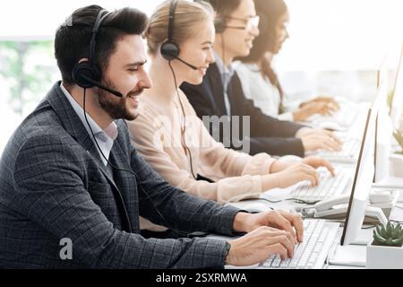 Telemarketing or hotline operators working with computers at light office Stock Photo